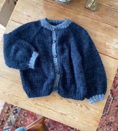 a blue sweater sitting on top of a wooden table