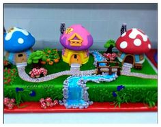 the cake is decorated with mushrooms and houses