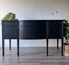 two black dressers sitting next to each other on top of a hard wood floor