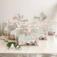 six clear bags filled with cookies and sunglasses on top of a table covered in flowers