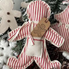 two red and white striped gingerbread man ornament hanging from a christmas tree