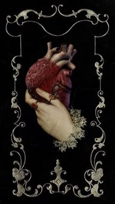 a woman's hand holding a heart in the shape of a frame on a black background