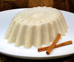 a white plate topped with a cake covered in icing and cinnamon sticks