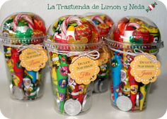 three plastic jars filled with candy and candies on top of a table next to a sign that says la trasteria del limoon y neda