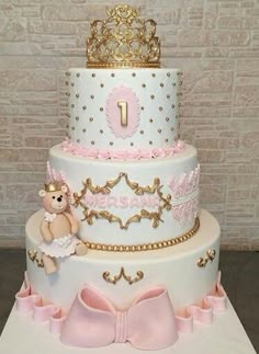 a three tiered cake with pink and gold decorations