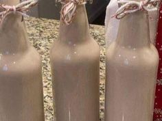 three empty milk bottles tied with twine are sitting on a counter top next to each other