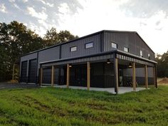 a two story house with an attached garage and covered porch in the middle of a grassy area