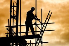 a man standing on top of a building next to scaffolding