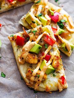 chicken, avocado and tomato pizza slices on parchment paper