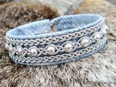 a close up of a bracelet with beads on it's side and fur in the background