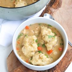 two bowls filled with dumplings on top of a wooden cutting board