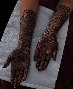 two hands with henna designs on them