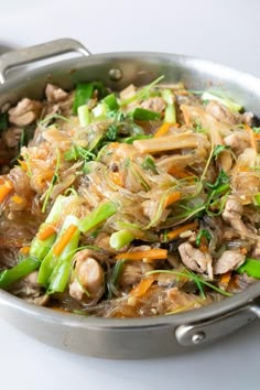 a pan filled with meat and vegetables on top of a table