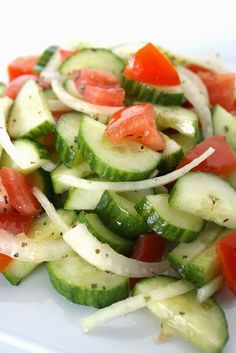 a white plate topped with cucumbers and tomatoes