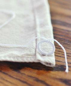 a close up of a piece of cloth on a wooden table with an object in the background