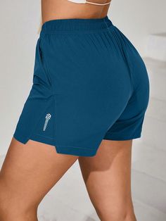 a woman in blue shorts is posing for the camera