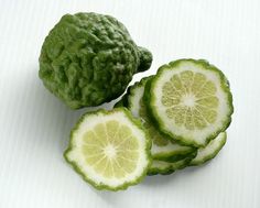 three limes cut in half sitting next to each other on a white tablecloth