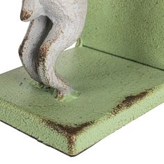 a small figurine of a white bear on a green base