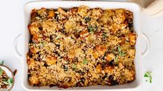 a casserole dish with meat and vegetables in it on a white counter top