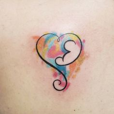 a woman's back with a heart shaped tattoo on it