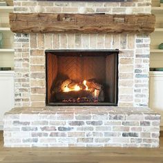 a brick fireplace with wood burning in it