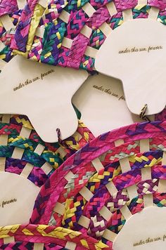 several pieces of colorful woven paper with words on them