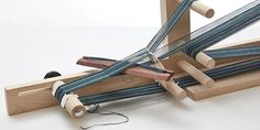 a group of wooden looms sitting on top of a white table next to each other