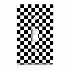 a black and white checkerboard light switch cover with an outlet in the middle