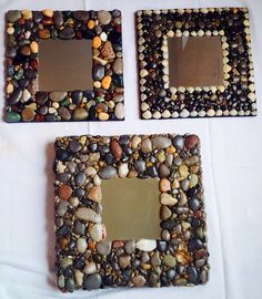 there are two small square mirrors made out of rocks and stones on the table top