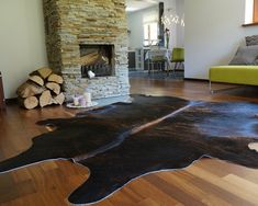 a living room with wood flooring and a fire place in the middle of it