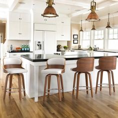 three bar stools sit in front of an island