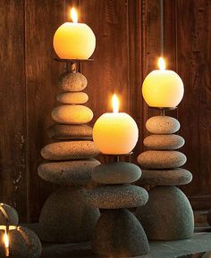 candles are lit in front of rocks stacked on top of each other