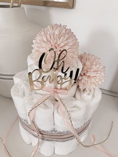 there is a cake that says oh baby on it with flowers in the middle and a ribbon around the top