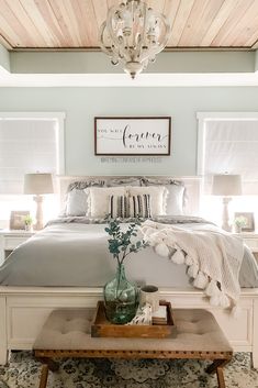 a bedroom with a bed, nightstands and a chandelier above the bed