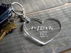 a heart shaped keychain with the word mom engraved on it