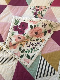 a quilt with flowers and polka dots on the bottom is laying on top of it