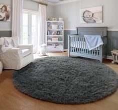 a baby's room with a gray rug and white furniture