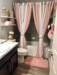 a bathroom with pink rugs and curtains