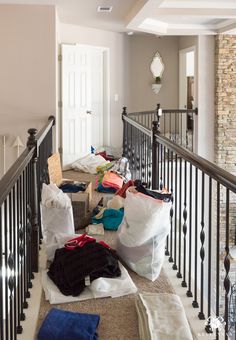 bags and clothes on the ground in front of a stair case