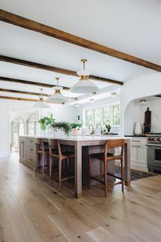 a kitchen with wooden floors and white walls