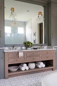 a bathroom vanity with two sinks and large mirror above it, along with other items on the counter