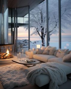 a living room filled with furniture and a fire place in front of a window overlooking the water