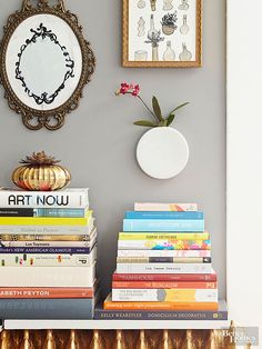 a stack of books sitting on top of a table next to a vase with flowers