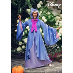 a woman dressed in blue and purple is holding a wand while standing next to a pumpkin