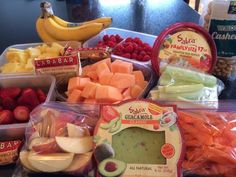 various fruits and vegetables in plastic containers on a table