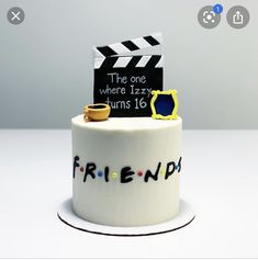 a birthday cake with a movie clapper on top and friends written on the side