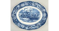 a blue and white plate with an image of people in a boat