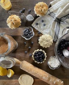 an assortment of baked goods on a wooden table with lemons, blueberries and other ingredients