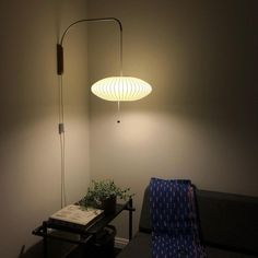 a living room with a couch, table and lamp on the wall next to it