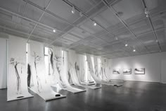 an art gallery with white walls and paintings on the wall, all in black and white